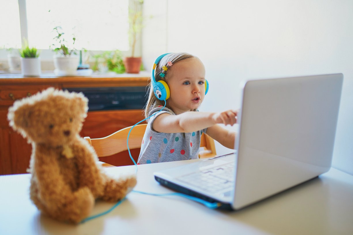 Toddler Girl Wearing Earphones with Laptop